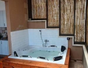 a large bath tub in a room with at Art & View Family Jacuzzi Suite with Balcony in Maghār