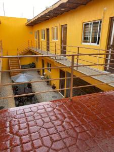 a yellow building with a staircase next to it at Hotel Santa Cecilia in Villa Corona