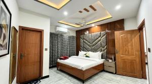 a bedroom with a bed and a wooden door at Standard Elite Palace inn Hotel in Islamabad