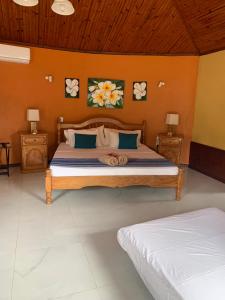 a bedroom with a bed with two night stands and two lamps at Amitie Chalets Praslin in Grand Anse