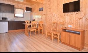 a kitchen with a table and chairs in a room at Domki CLAUDIA in Darłowo