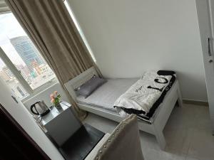 a small bed in a room with a window at Fabulous Room in Muşaffaḩ