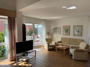 a living room with a couch and a tv at Fewo Bad Salzuflen in Bad Salzuflen
