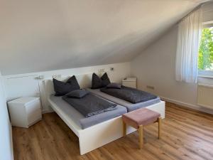 a white bedroom with two beds and a chair at Fewo Bad Salzuflen in Bad Salzuflen