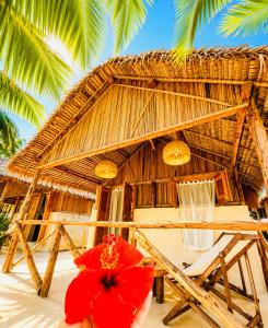 a red umbrella sitting in front of a straw hut at Tao Resort in Andavakonko