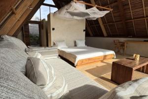 a bedroom with two beds and a hammock in it at Tao Resort in Andavakonko
