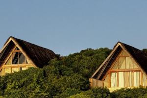 a couple of houses with trees in the background at Tao Resort in Andavakonko