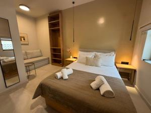 a bedroom with a large bed with towels on it at Divine Suites Tinos in Tinos +39 photos