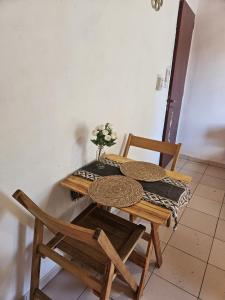 a table with two chairs and a vase of flowers on it at Terraza Perito Moreno in Villa Carlos Paz