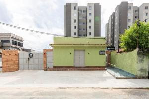 a green building in front of some tall buildings at Loft Essence in Volta Redonda