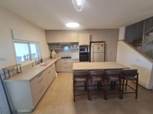 a kitchen with a table and chairs and a refrigerator at וילה נוף הרים שלומי in Shelomi