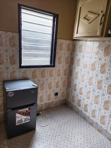ein kleiner Kühlschrank in einem Zimmer mit Fenster in der Unterkunft Lavignon in Taméklo
