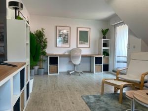 a living room with a desk and a chair at Deep Blue Dümmer - Apartment in Lembruch