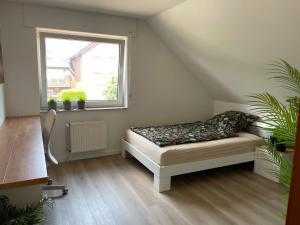 a room with a bed sitting under a window at Deep Blue Dümmer - Apartment in Lembruch