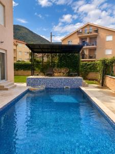 a swimming pool with a gazebo next to a building at Apart-pool Tivat in Tivat