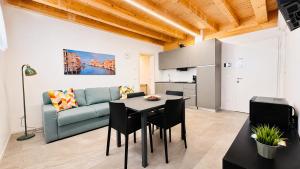 a living room with a blue couch and a table and chairs at Venice Easy Stay Meolo in Meolo