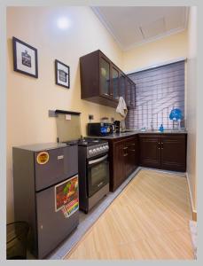 a kitchen with wooden cabinets and a stove top oven at HM Homes in Morogoro