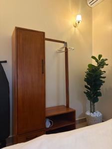 a bedroom with a wooden cabinet and a potted plant at HM Homes in Morogoro +26 photos