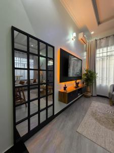 a living room with a tv and a large mirror at HM Homes in Morogoro