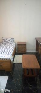 a bedroom with two beds and a desk and a table at Chambre d'hôtes à louer in Pikine