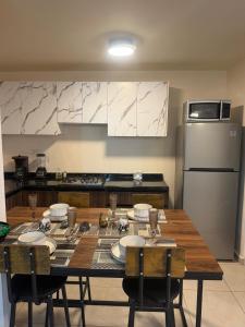 a kitchen with a wooden table with chairs and a refrigerator at Executive Apartment for 6 people in El Colorado
