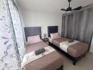a bedroom with two beds and a ceiling fan at Executive Apartment for 6 people in El Colorado +6 photos