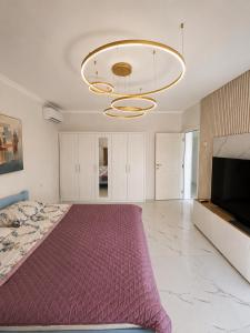 a large bedroom with a large bed and a chandelier at Apart-pool Tivat in Tivat +24 photos