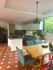 a kitchen with a wooden table and blue chairs at Entre Pajaros y Flores in Rivera