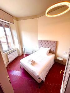 a bedroom with a white bed and a large window at Augusta e Libero Apartments in Spoleto