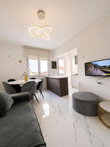 a living room with a table and chairs and a tv at Apart-pool Tivat in Tivat