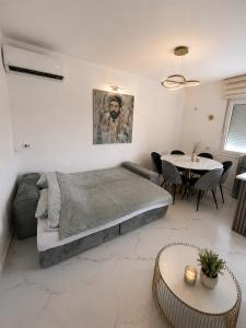 a bedroom with a bed and a table with chairs at Apart-pool Tivat in Tivat