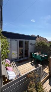 a wooden deck with a table and a bench at The Shack in East Wittering