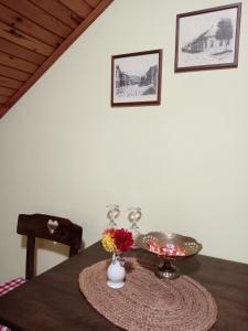 a table with a plate and flowers on it at Putnicka kuca kod Dragane in Bajina Bašta