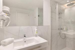 a white bathroom with a sink and a shower at B&B HOTEL Madrid San Fermin in Madrid +24 photos