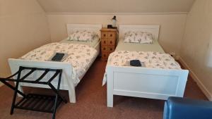 two beds sitting next to each other in a room at Vakantiewoning Blauhûs in Surhuisterveen