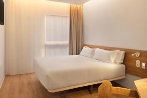 a white bed in a room with a window at B&B HOTEL Madrid San Fermin in Madrid