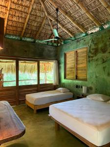 una camera da letto con due letti e due finestre di COCOS HOTEL a Zipolite