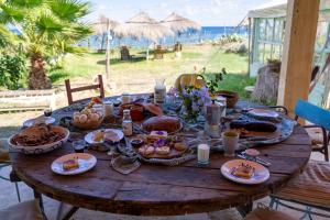 a table with food on it with the beach in the background at Cap carav'ânes in Banī ‘Aţāʼ
