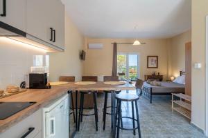 a kitchen and living room with a table and chairs at Maria Anastasia Studios in Trapezaki