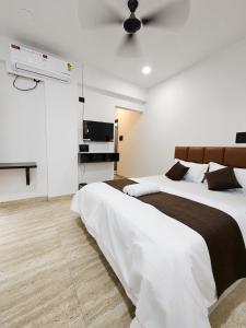 two beds in a bedroom with white walls at Hotel Pune Grand in Pune