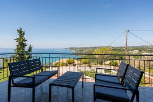 a balcony with two chairs and a view of the ocean at Maria Anastasia Studios in Trapezaki