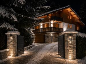 a house with a gate in the snow at night at Chalet Greystone in Brides-les-Bains +43 photos