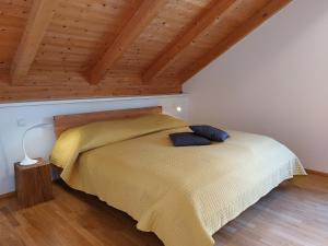 a bedroom with a yellow bed with a wooden ceiling at Kelchalm Superior Spacious Mountain Apartment in Bad Kleinkirchheim
