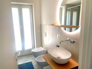 a bathroom with a sink and a toilet and a mirror at Le Port Vieux in Pesaro +17 photos