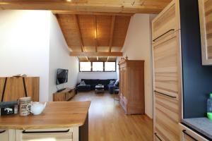 a kitchen and living room with a wooden ceiling at Kelchalm Superior Spacious Mountain Apartment in Bad Kleinkirchheim