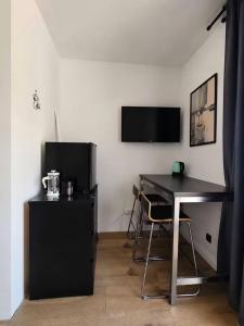 a black desk with a chair and a television in a room at Garden Haus Livno in Livno