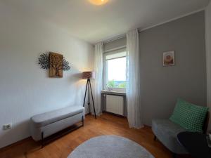 a living room with a chair and a window at Landblick Halver - Ferienwohnung mit Balkon in Halver