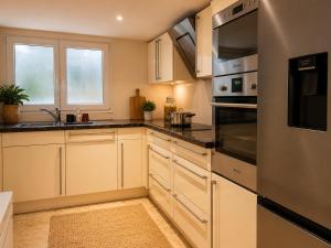 a kitchen with white cabinets and stainless steel appliances at Nest am Rhein in Öhningen