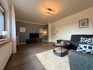 a living room with a couch and a table at Landblick Halver - Ferienwohnung mit Balkon in Halver