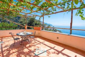 a table and chairs on a balcony with a view of the ocean at Villa Borgo San Michele in Amalfi